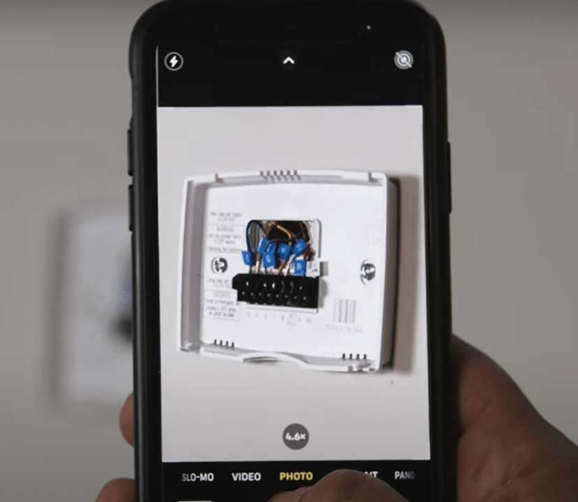 Photo du câblage interne d'un thermostat prise avec un smartphone